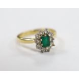 A modern 18ct gold, emerald and diamond set oval cluster ring, size L/M, gross weight 4.9 grams.