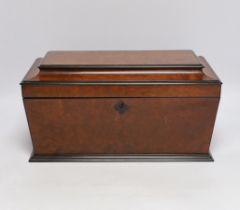 A George IV amboyna and ebony banded sarcophagus shaped tea caddy, with pedestal glass bowl, 35.