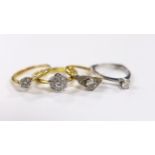 Three assorted 18ct and solitaire diamond rings and an 18ct gold and diamond set flower head ring,