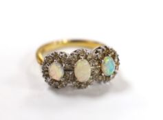 An 18ct, white opal and diamond chip set triple cluster dress ring, size K, gross weight 4.2 grams.