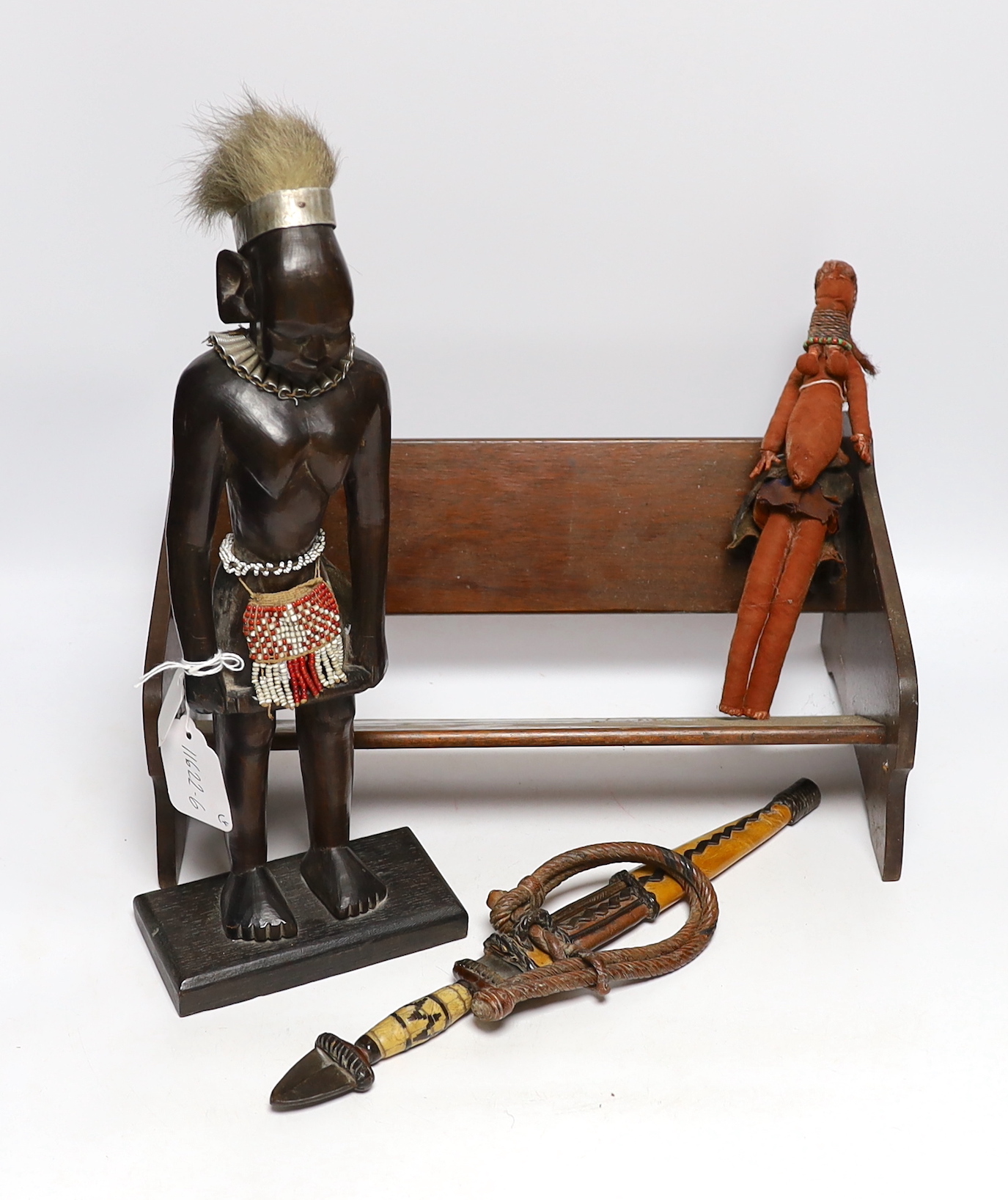 A collection of tribal items including fabric doll, African carved wood figure and dagger, largest