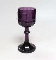 A Bohemian amethyst goblet, seemingly cut from a single piece of glass in a facetted form with a