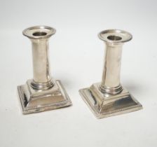 A pair of late Victorian silver dwarf candlesticks, with beaded borders, Edward Hutton, London,