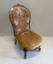 A Victorian walnut spoon back nursing chair, retaining original floral tapestry to back, width 50cm,