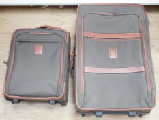 A Longchamp leather and canvas suitcase and a smaller 'carry on' case, largest 70cm high