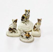 Four Staffordshire porcelain models of tortoiseshell cats, c.1830-50, three seated on shaped