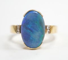 A yellow metal and black opal oval dress ring, with diamond chip shoulders, size P, gross weight 5.7
