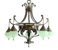 An English Arts & Crafts brass light fitting by Faraday & Son, of circular scrolling design, hung