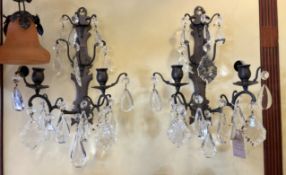 A pair of 1920's French bronzed wrought iron wall sconces hung with cut and facetted glass drops,