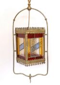 An Edwardian brass gasolier hall lantern with stained glass panels, now converted to electricity,