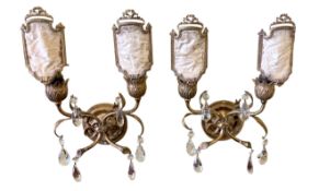A pair of early 20th century English brass twin branch wall lights hung with facetted glass drops,