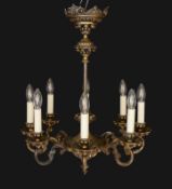 An early 20th century Austrian cast bronze eight light electrolier with foliate scroll branches,