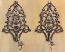 A pair of Victorian silvered metal wall sconces with sunflower design backplates and plain candle