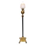 An Edwardian brass and ebonised oil lamp standard with Invicta mechanism and frosted glass shade,