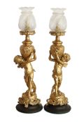 A pair of early 20th century French gold painted spelter table lamps modelled with cherubs after