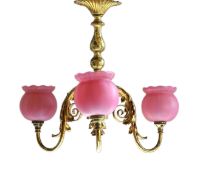 An early 20th century French brass light fitting with foliate branches and satin pink glass