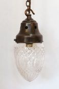 A 1920's English cut glass acorn pendant, with gallery, chain and ceiling rose, patinated bronze