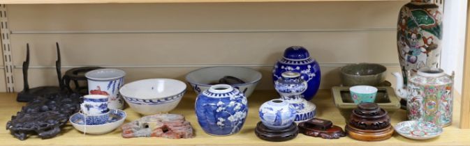 A collection of Chinese items including hardwood stands and a soapstone example, a blue and white