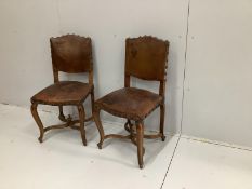 A pair of late 19th French Louis XV style carved oak dining chairs, with brown leather upholstery