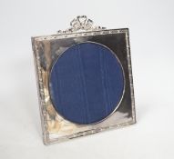 An Edward VII silver easel photograph frame with ribbon crest and circular aperture, Chester 1906,
