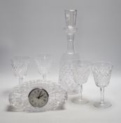 A Waterford cut glass decanter, four glasses and a timepiece