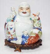 A 20th century Chinese porcelain Buddha on hardwood stand, 28cm