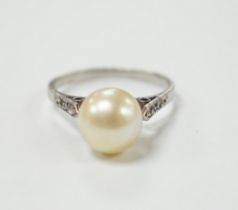 A white metal solitaire cultured pearl ring with diamond set shoulders, size J