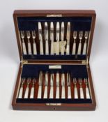 A cased set of twelve pairs of George V silver mother of pearl handled dessert knives and forks,