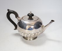 A Victorian silver bullet shaped teapot, with ebonised handle and gadrooned body, marks rubbed,