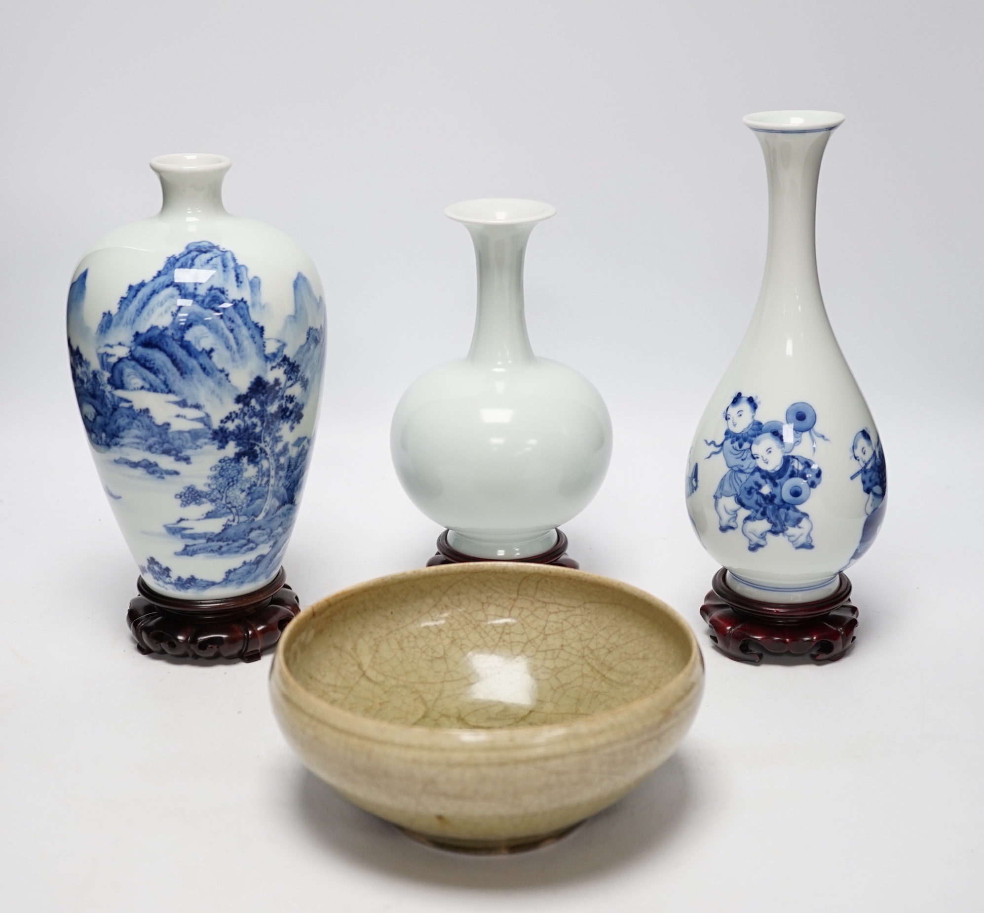 Two modern Chinese blue and white vases on stands, a crackle glaze celadon bowl and vase, tallest