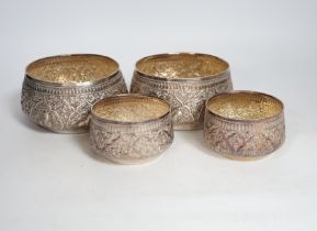 A pair of Thai circular white metal bowls, and a pair of small bowls, all decorated with animals and