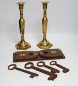 A group of mixed metalware including a pair of brass candlesticks, a brass bound book slide, iron