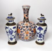 A pair of Chinese blue and white crackleware vases and covers and an Imari vase and cover, largest