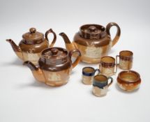 An assortment of Doulton stoneware including teapots, miniature tygs and twin handled pots, some