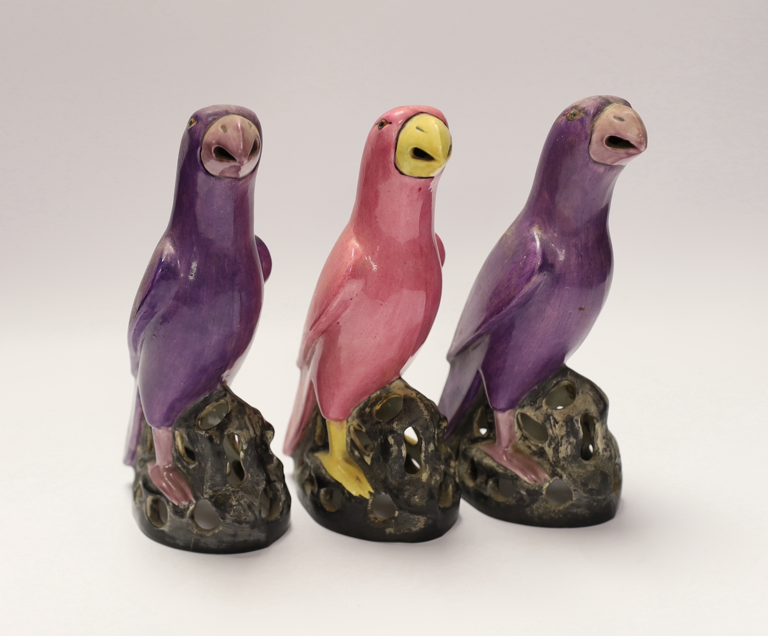 Three Staffordshire parrots with purple and pink glazed, each stamped, 19cm high