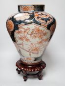 A Japanese Arita Imari pattern vase, c.1690, restored, with an unmatched wooden stand, vase 31cm