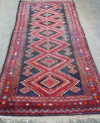 A Belouch blue and red ground rug, 256 x 116cm