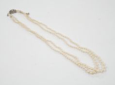 A 1940's double strand graduated cultured pearl necklace, with diamond set white metal clasp, 46cm.