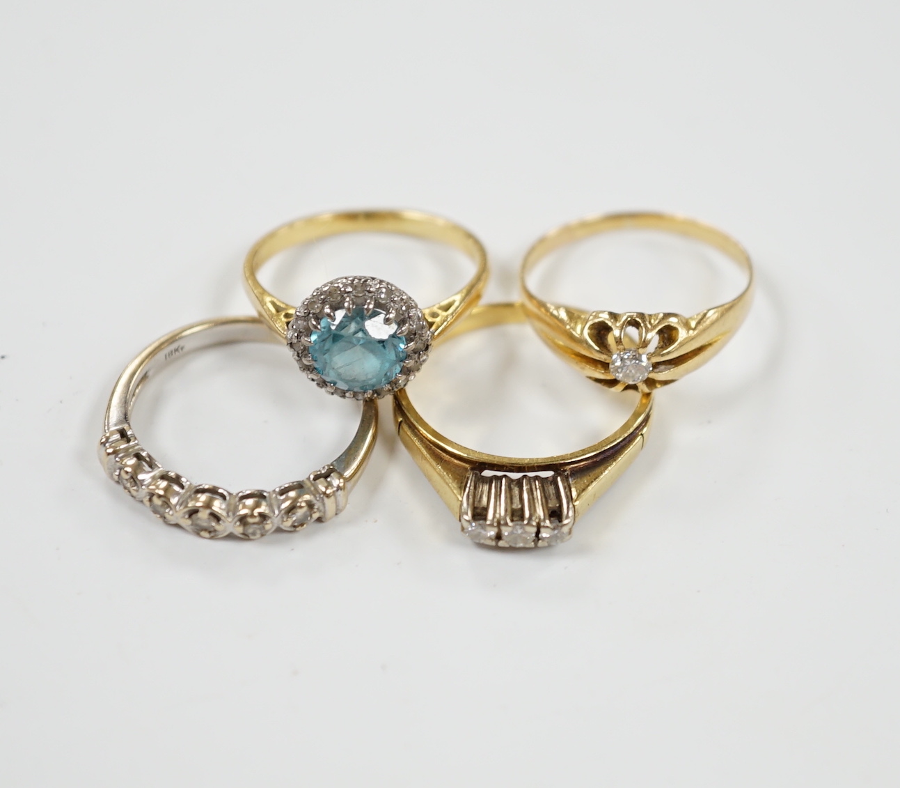 Three assorted 18ct and gem set dress rings, including blue zircon and diamond chip and claw set