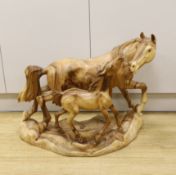 A large wooden carving of a horse and foal, 70cm wide