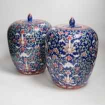 A pair of Chinese blue ground jars and covers, 29cm
