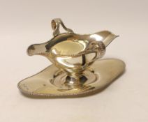 An Edwardian silver double lipped sauceboat and stand, Barker Brothers, Chester, 1907, stand 17.9cm,