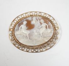 A yellow metal mounted oval cameo shell brooch, carved with two seated ladies with sheep, beneath