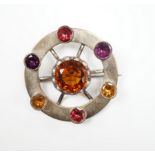 A white metal and multi gem set openwork circular brooch, with central dark citrine, diameter 49mm.