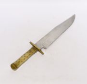 A Bowie knife with clip point blade, unsharpened false edge and decorative filework, marked made