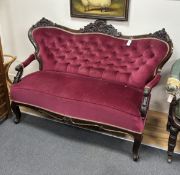 A late 19th century Austro-Hungarian carved mahogany settee with buttoned burgundy upholstery,