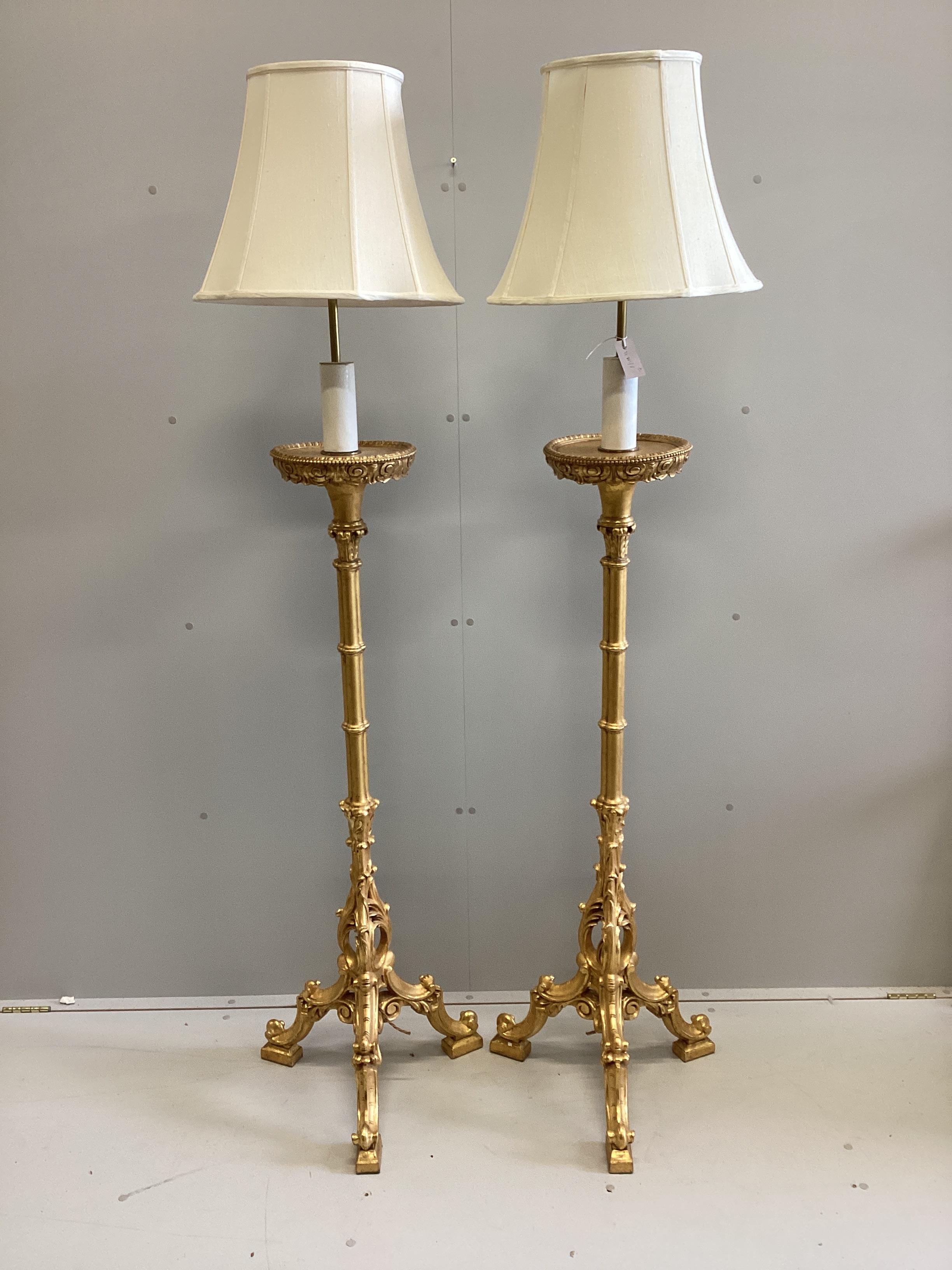 A pair of 18th century style carved gilt cluster column tripod standard lamps, height including