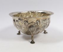 A George V Irish embossed silver circular bowl, on three cabriole legs with hoof feet, West & Son,