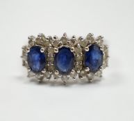 An 18k white metal, sapphire and diamond set triple cluster ring, size Q. gross weight 5.8 grams.