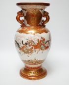 A Japanese Kutani porcelain twin handled vase, Meiji period, decorated with warriors on horseback,